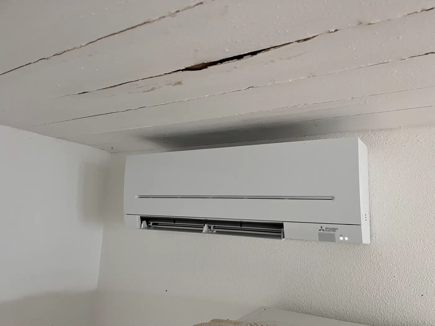 Climatizzatore a parete installato sotto un soffitto in legno